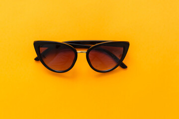 Yellow sun glasses isolated over the yellow background