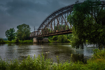 Railway bridge over the river on a cloudy day.