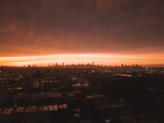 Aerial View from Brooklyn over far away Manhattan Skyline in the Distance after Sunset with Fire Red Light and Skyscraper Silhouette 