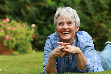 Happy attractive senior woman in her garden