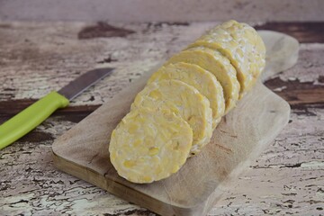 Slices of tempeh (fermented soybean) on the wooden board