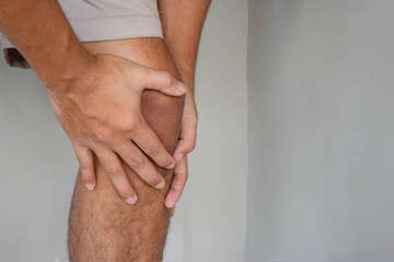 Man holds on to knee, pain in knee. People with knee pain and feeling bad hand on he knee, healthy concept.