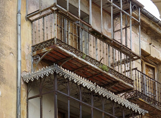 Dilapidated building with rusty metallic enclosed balconies in the city of Sigüenza. Guadalajara....