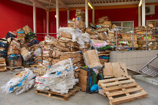 A large pile of cardboard boxes from the goods sold, stored in the back of the supermarket. The concept of urban pollution