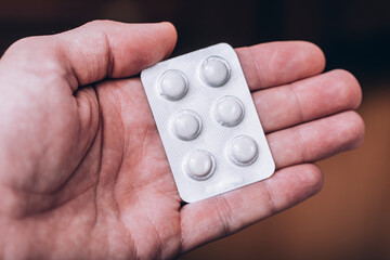 Top view of the pills on the hand on dark background. A hand hold the pills and drug, Pile of the drug and pills on the hand.