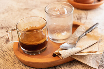 Espresso coffee in glass cup on wooden tray