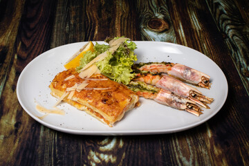 Langoustines with young potatoes. A dish with large king prawns, lobsters with vegetables. Seafood with a panel, a delicious seafood delicacy, a source of omega 3