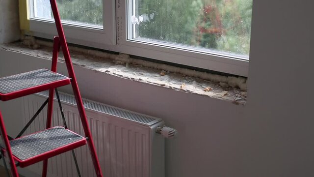 Repair in the slopes of the window. The process of applying a layer of plaster on the sides of the window.