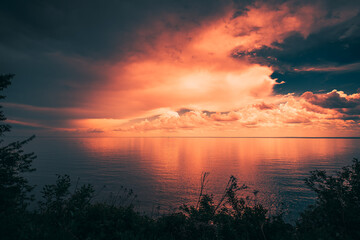 Dramatic Sunset Clouds over Water Horizon with Reflection