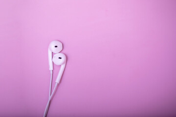 Lovely earphones. White earphones on pastel pink background. Music is my life concept. Valentine concept. World music day.