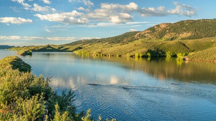 Fototapeta premium open water swimmers with swim buoys on a calm lake, summer morning workout