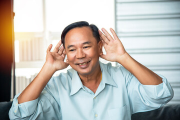 Senior Asian adult father is chatting, listening to video calls, starting to work online warmly in the morning at home. The concept of family life is Popular today