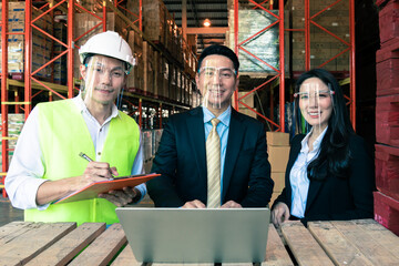 Asian business man, woman and engineer wear protective face shield smile in warehouse 