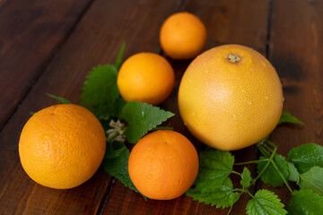 oranges and grapefruit on a brown wooden background, top view, text space, citrus