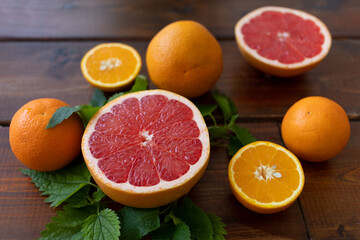 oranges and grapefruit on a brown wooden background, text space, citrus