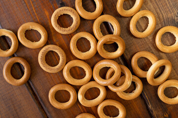 bagels on a brown wooden background, top view, place for text, baking, drying