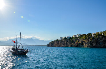 The tourist boat with turkish flag floating on the Mediterranean sea in the city of Antalya in Turkey
