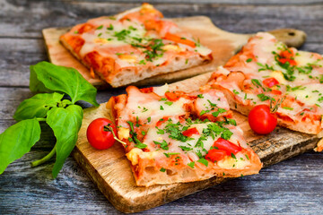 Fototapeta na wymiar Assorted sliced italian roman style pizza. with parmesan cheese, ham, mushrooms and tomato sauce 