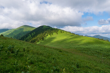 Naklejka premium Green ridge in mountain and blue cloud sky. Composition of nature. Spring ountain. Composition of nature. Slovakia little fatra europe