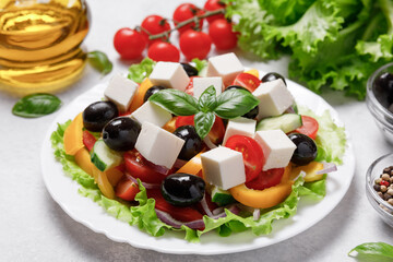 Greek salad with cheese and fresh vegetables on white background.