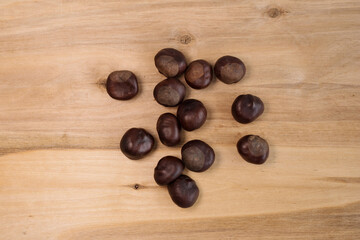 chestnut fruits scattered on a wooden background