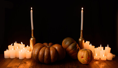 Halloween pumpkin on the background of candles and a black background.