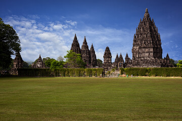 Prambanan Hindu Temple view in Yogyakarta, Java Island, Indonesia, its most beautiful Hindu temple in Indonesia. View with blue sky background and green grass garden foreground