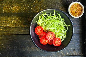 zucchini spaghetti salad tomato vegetables Menu concept serving size. food background top view copy space organic healthy eating keto or paleo diet