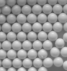 Closeup of white plastic bb's lined up on flat background