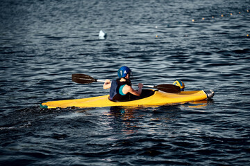 A guy wearing a helmet on a canoe polo rowing a paddle and sailing on water. canupolo. puts on a...