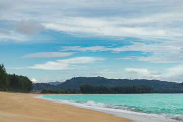 Fototapeta na wymiar sand sea beach with pine tree and mountain, blue sky background