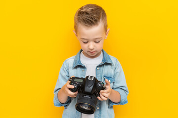 Happy little boy looks through photos on camera