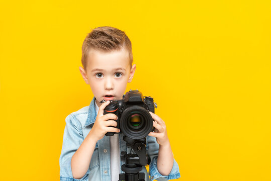 Adorable boy taking a photo using a digital camera on a tripod