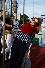 Attractive smiling woman riding on a merry go round at fair
