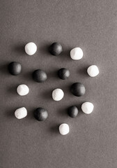 Black and white plasticine balls mixed on a grey background surface. Concepts of unity and togetherness, all balls together mixed with no segregation