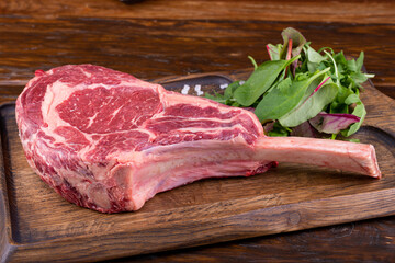 Steak ribay raw, served with spices and fresh greens