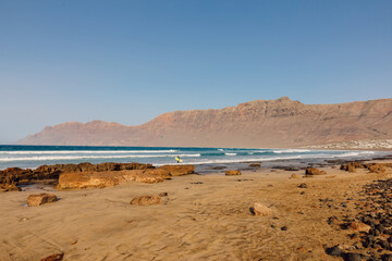 Famara beach, scenic landscape with ocean waves and mountains in Lanzarote