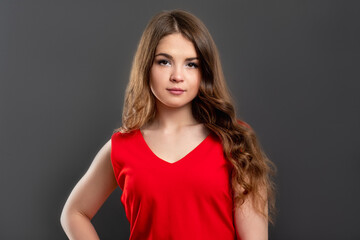 Obraz premium Confident woman portrait. Female power. Independent lady in red top isolated on gray background.