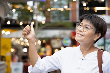 middle aged aunt, old woman showing thumb up gesture