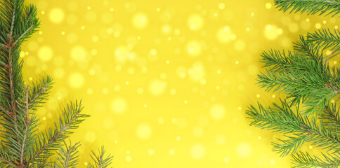     christmas tree branches on yellow festive background bokeh lights,   copy space     