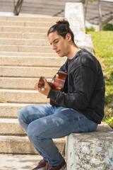Obraz premium young man playing spanish guitar on the field 