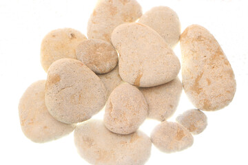 Gray smooth sea stones from the shore on a white background. Backlight below.