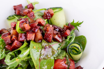 Fried bacon with cream sauce, fresh greens and vegetables