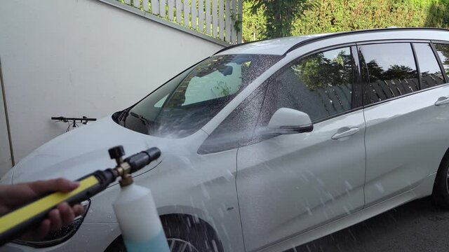 Car wash. Cleaning the car effectively by using a high pressure foam gun. The foam sticks to the car for a good while letting the dirt dissolve properly. Shot in 4K.