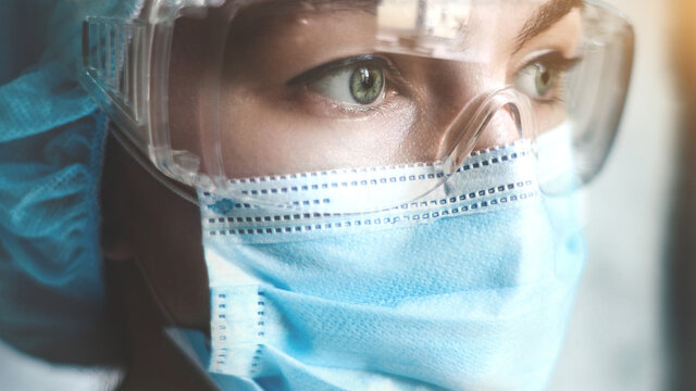 Nurse With Mask During The Coronavirus Pandemic, And In Safety Glasses, Gloves. Close Up