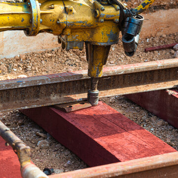 Railway workers bolting track rail. Detail worker with Light portable sleepers drilling machine