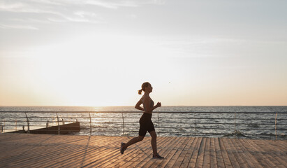 Healthy lifestyle. Young beautiful athletic woman goes in for sports in the morning. Run along the promenade.