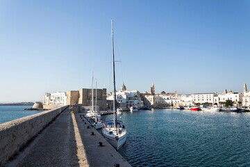 Beautiful boats in Monopoli port near Castle of Carlo V with church in background, Apulia, Bari...