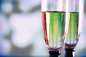 Background with tall glasses for sparkling wines. Champagne and spray in glass glasses. Celebratory drink with reflection.