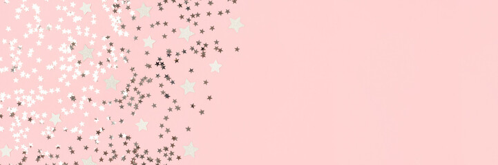 Banner with silver stars confetti on a pink pastel background. Shiny composition with copy space.